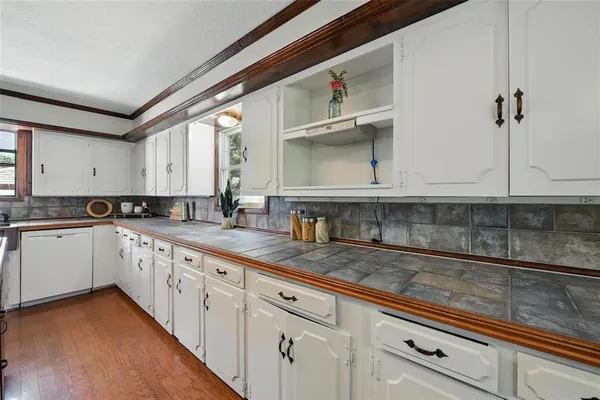 a kitchen with granite countertop white cabinets and white appliances
