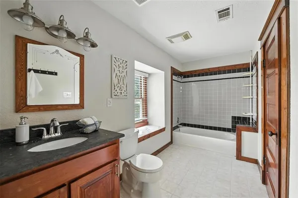 a bathroom with a granite countertop sink toilet and shower