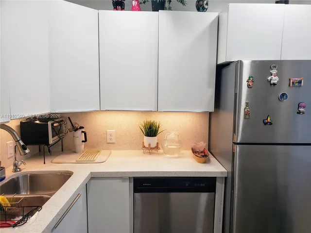 a kitchen with stainless steel appliances a sink a refrigerator and microwave