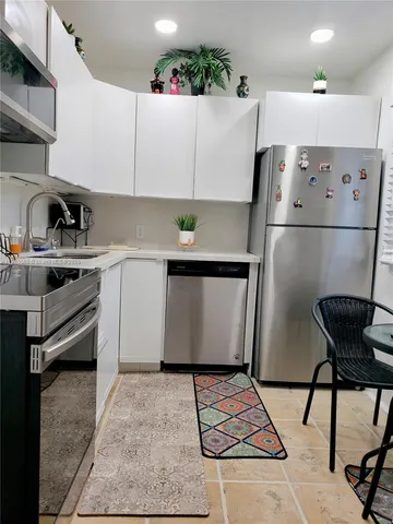 a kitchen with a stove a refrigerator and cabinets