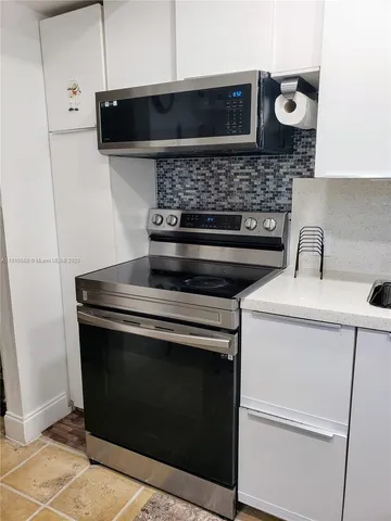 a stove top oven sitting inside of a kitchen