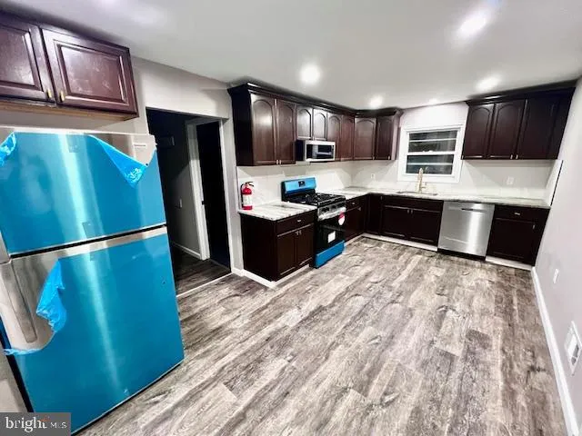 a kitchen with stainless steel appliances granite countertop a refrigerator and a sink