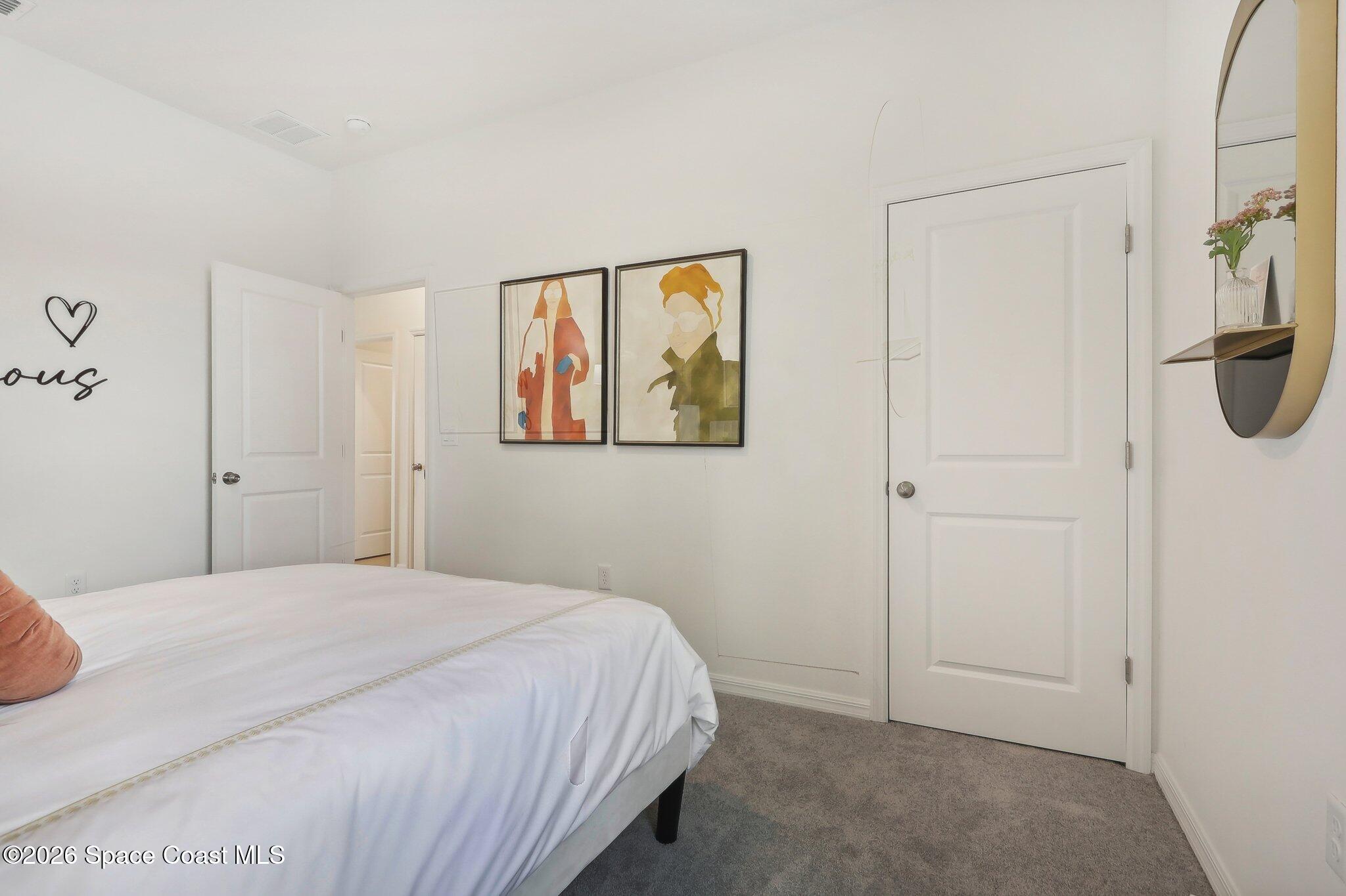 1332 Dunblane Way Northeast Palm Bay, FL 32905 - Photo 24 of 32 a bedroom with a bed and a painting on the wall