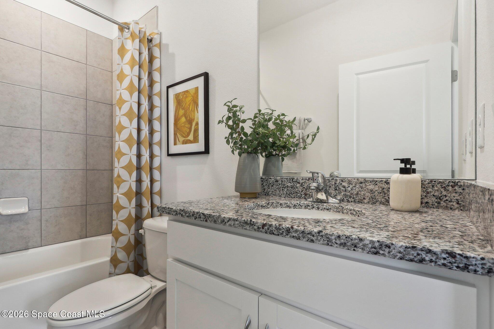 1332 Dunblane Way Northeast Palm Bay, FL 32905 - Photo 30 of 32 a bathroom with a granite countertop sink mirror toilet and bathtub