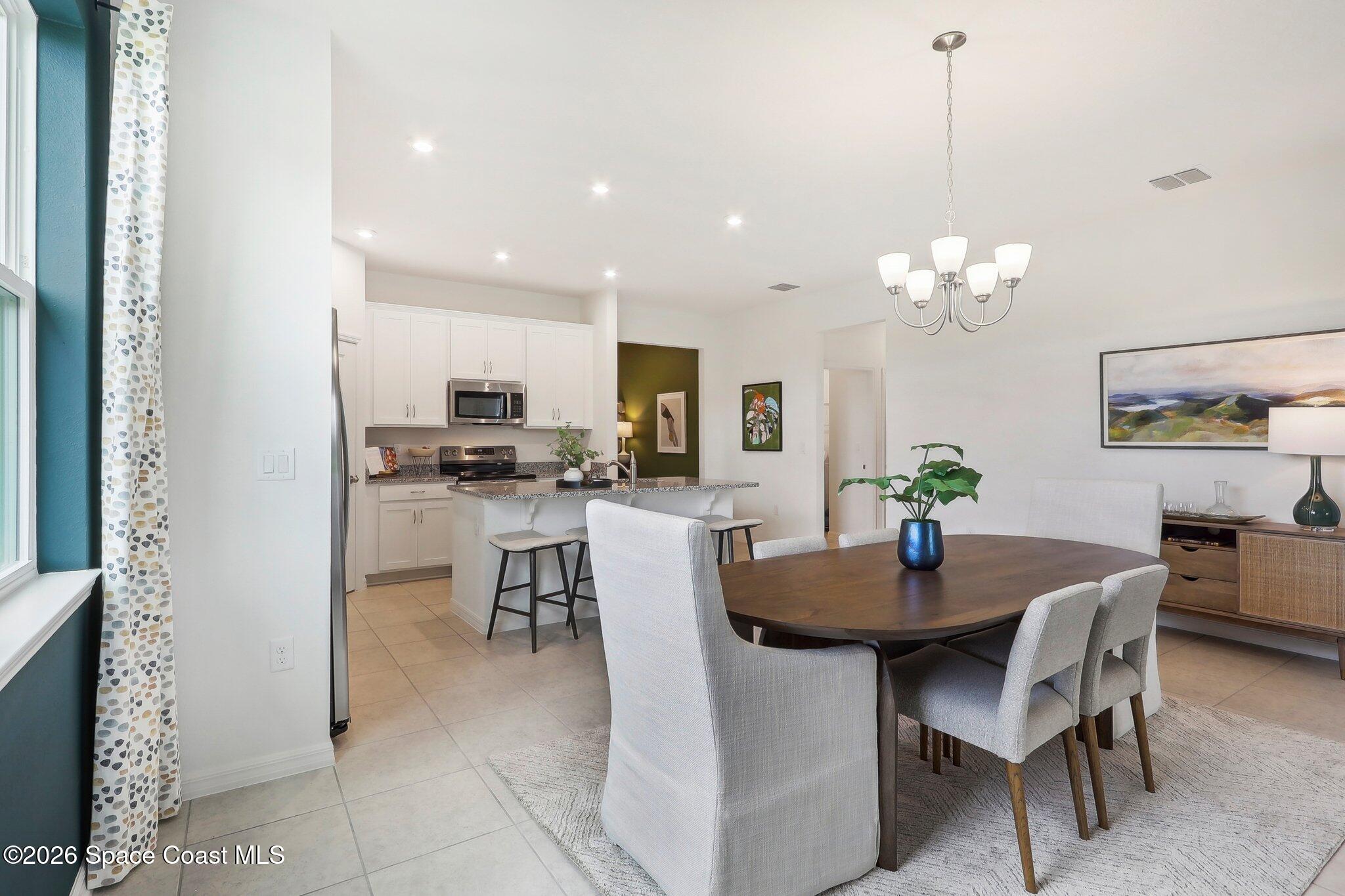 1332 Dunblane Way Northeast Palm Bay, FL 32905 - Photo 8 of 32 a view of a dining room with furniture and chandelier