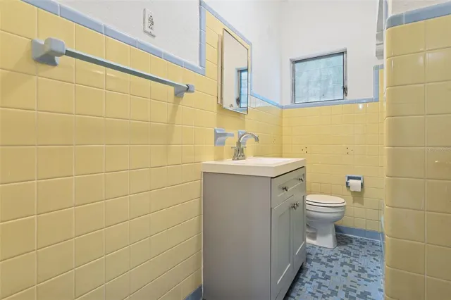 a bathroom with a toilet sink and a mirror