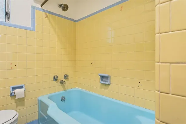 a bathroom with a tub and a toilet