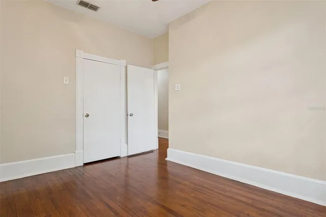 a view of an empty room with wooden floor