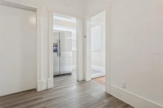 an empty room with wooden floor & closet area