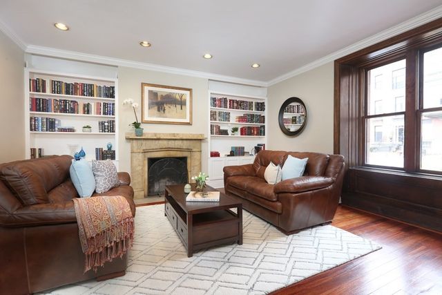 a living room with furniture a large window and a fireplace