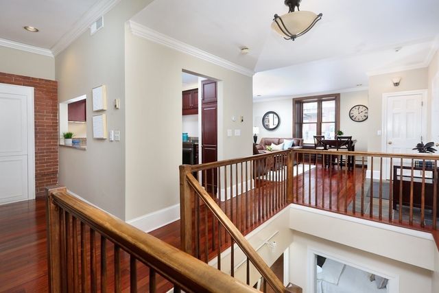a view of staircase with lots of frames on wall and a window
