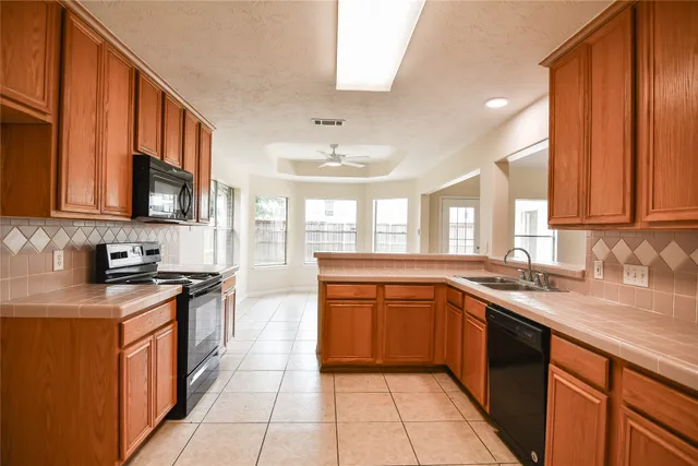 a kitchen with stainless steel appliances granite countertop a sink stove and cabinets