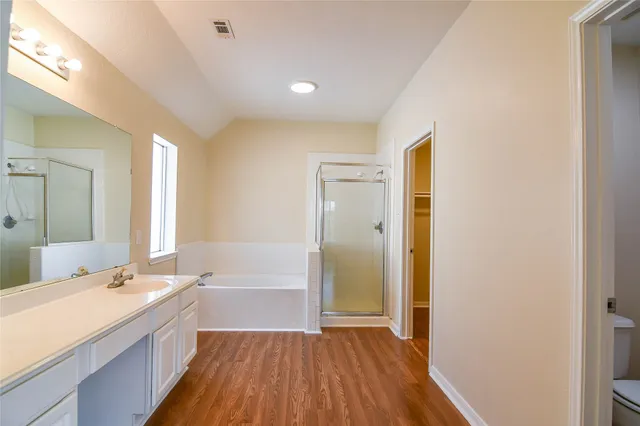 a bathroom with a double vanity sink a mirror and a bathtub