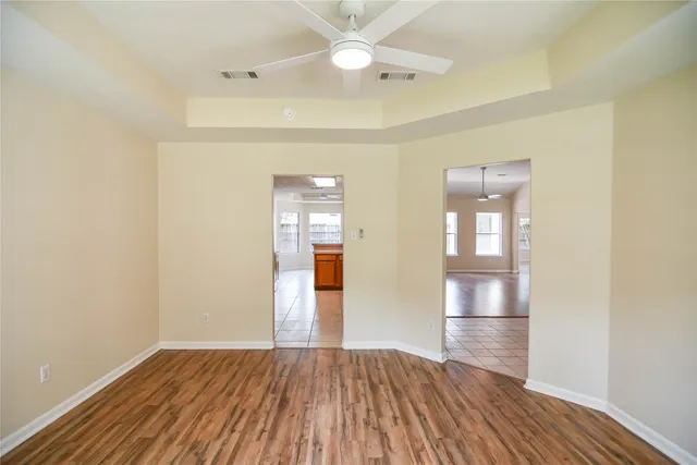 an empty room with wooden floor and windows