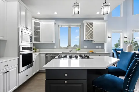 a kitchen with stainless steel appliances a sink stove and white cabinets