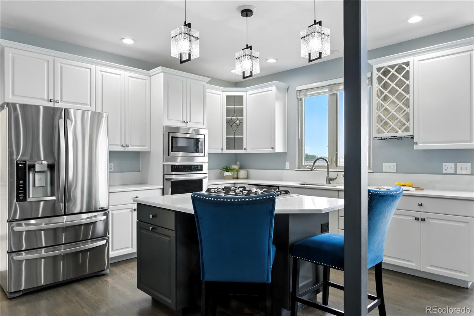 7092 Secrest Court Arvada, CO 80007 - Photo 15 of 49 a kitchen with kitchen island granite countertop stainless steel appliances a sink cabinets and a refrigerator