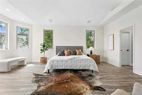 a spacious bedroom with a bed and wooden floor