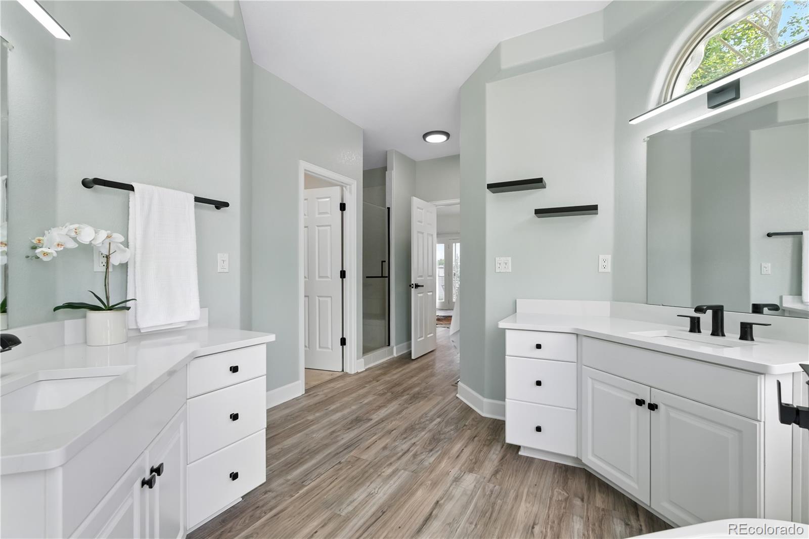 7092 Secrest Court Arvada, CO 80007 - Photo 22 of 49 a bathroom with a double vanity sink a mirror and shower