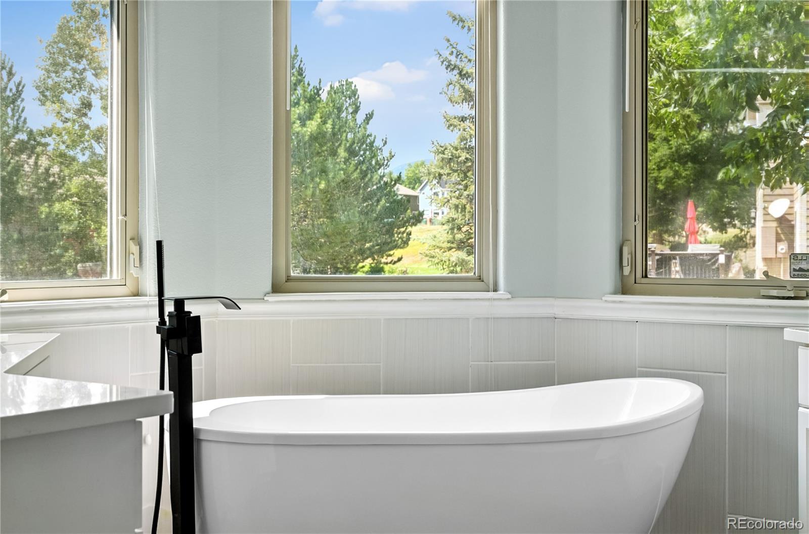 7092 Secrest Court Arvada, CO 80007 - Photo 24 of 49 a white bath tub sitting in a bathroom next to a window