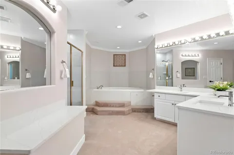 a spacious bathroom with a tub a double vanity sink a mirror and a bathtub