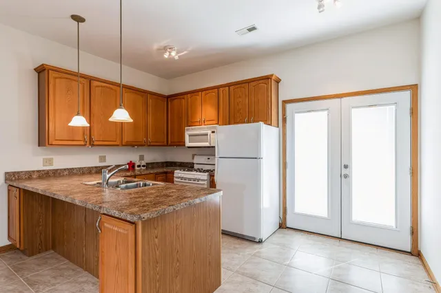 a kitchen with a sink a refrigerator and a cabinets