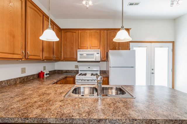 a large kitchen with a refrigerator and a sink