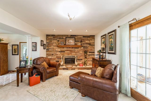 a living room with furniture fireplace and a large window