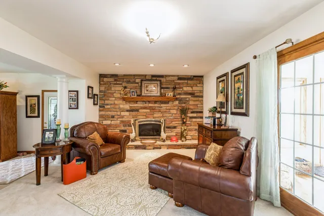 a living room with furniture fireplace and a large window