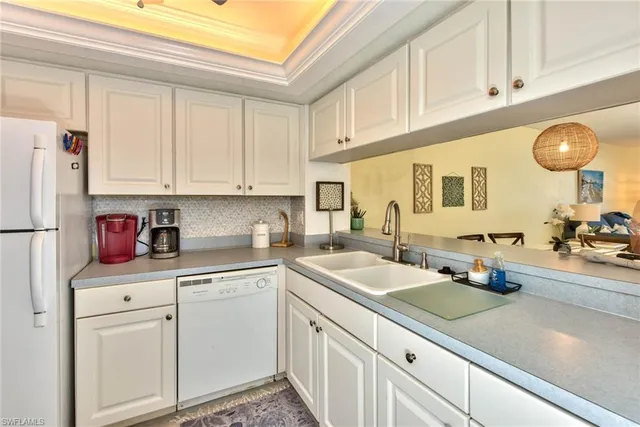 a kitchen with white cabinets and white appliances