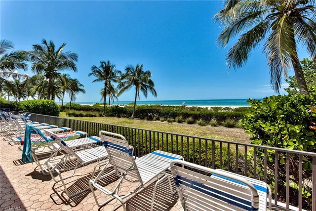 a view of balcony with furniture and ocean view