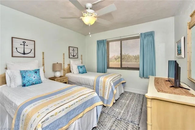 a bedroom with two beds and a chandelier