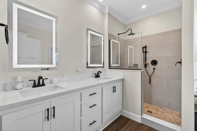 a bathroom with a double vanity sink mirror and shower