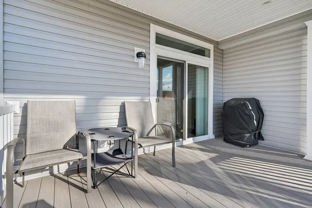 a view of a patio with table and chairs and floor to ceiling window