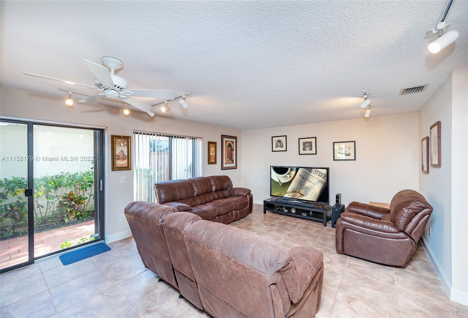 14853 Southwest 42nd Lane Miami, FL 33185 - Photo 13 of 28 a living room with furniture and a floor to ceiling window