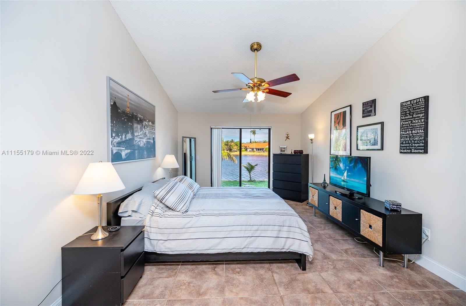 14853 Southwest 42nd Lane Miami, FL 33185 - Photo 15 of 28 a bedroom with a bed and a chandelier