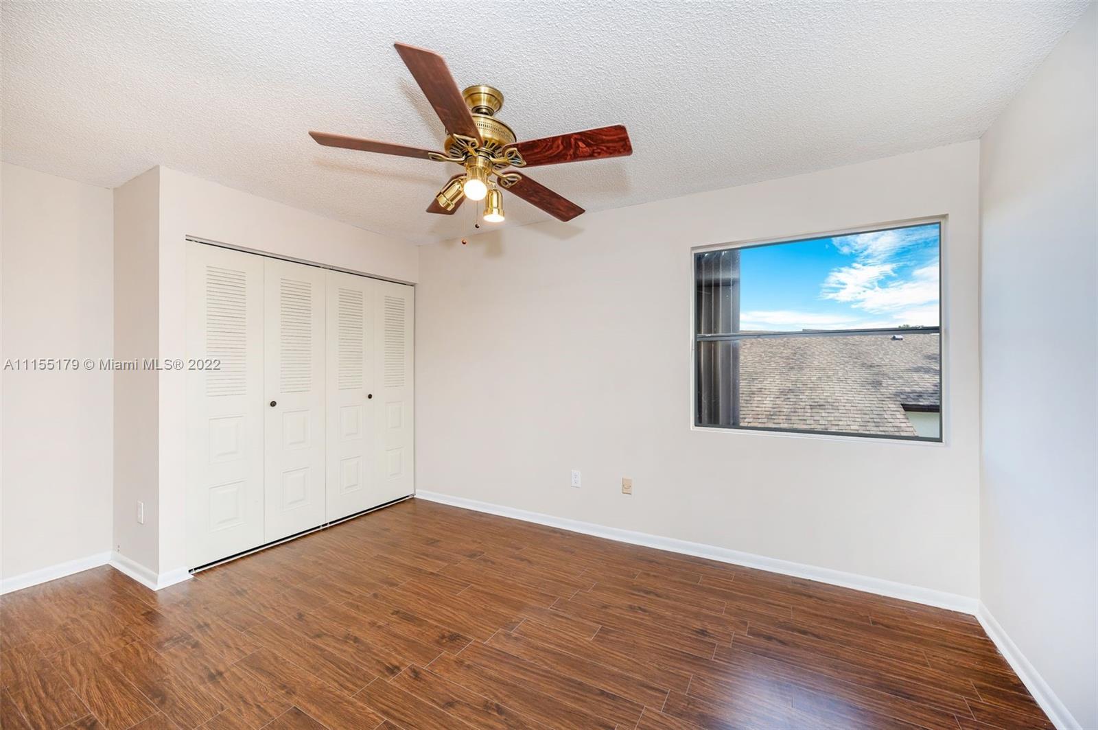 14853 Southwest 42nd Lane Miami, FL 33185 - Photo 21 of 28 an empty room with wooden floor fan and windows