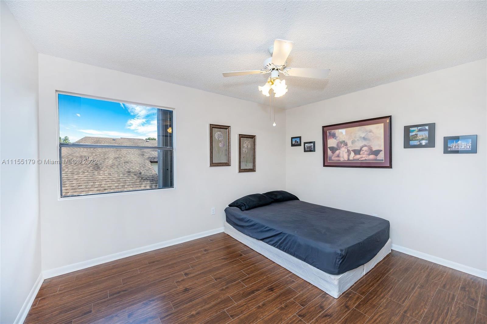 14853 Southwest 42nd Lane Miami, FL 33185 - Photo 22 of 28 a living room with wooden floor and ceiling fan
