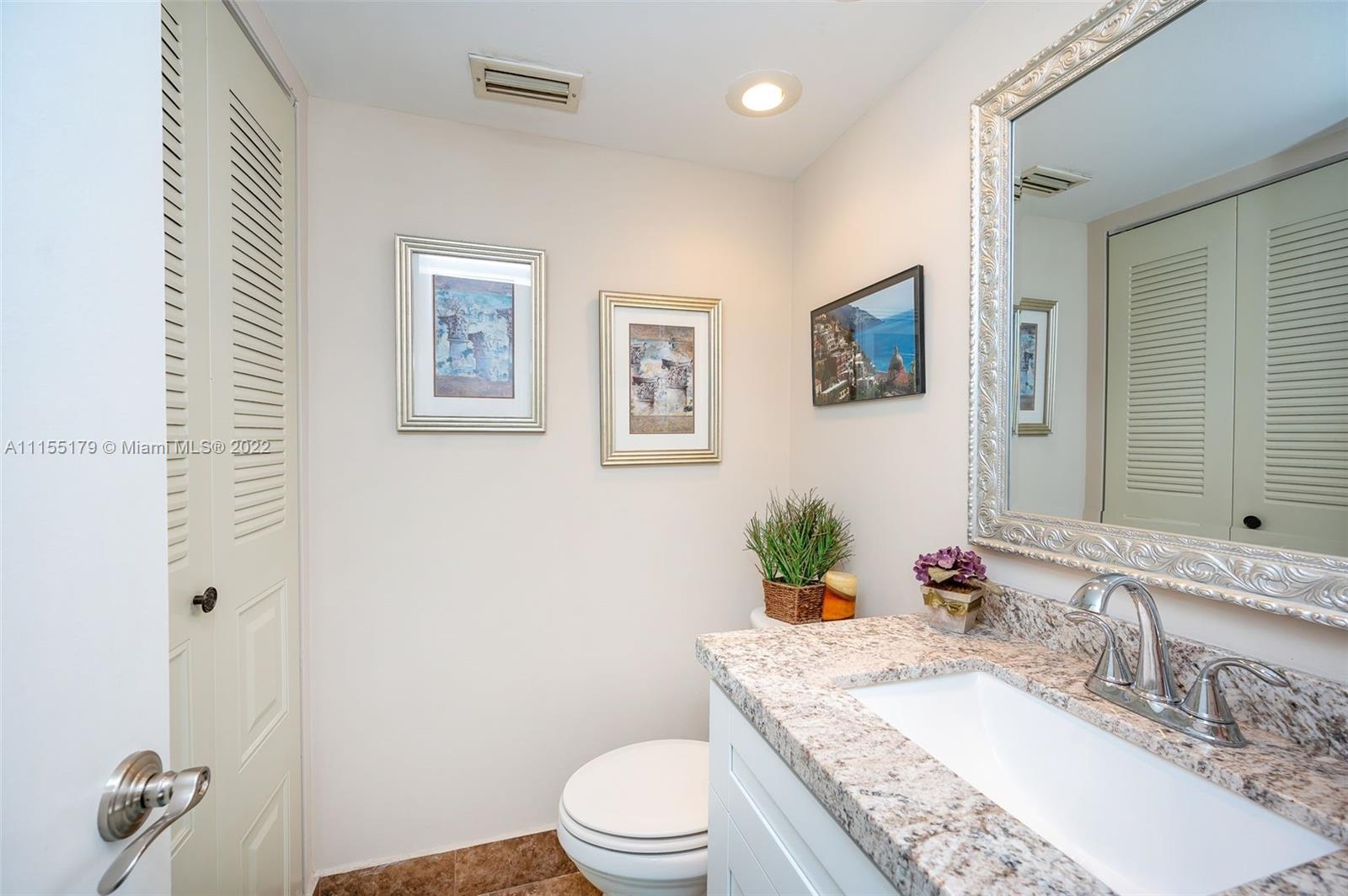 14853 Southwest 42nd Lane Miami, FL 33185 - Photo 25 of 28 a bathroom with a granite countertop toilet a sink and a mirror
