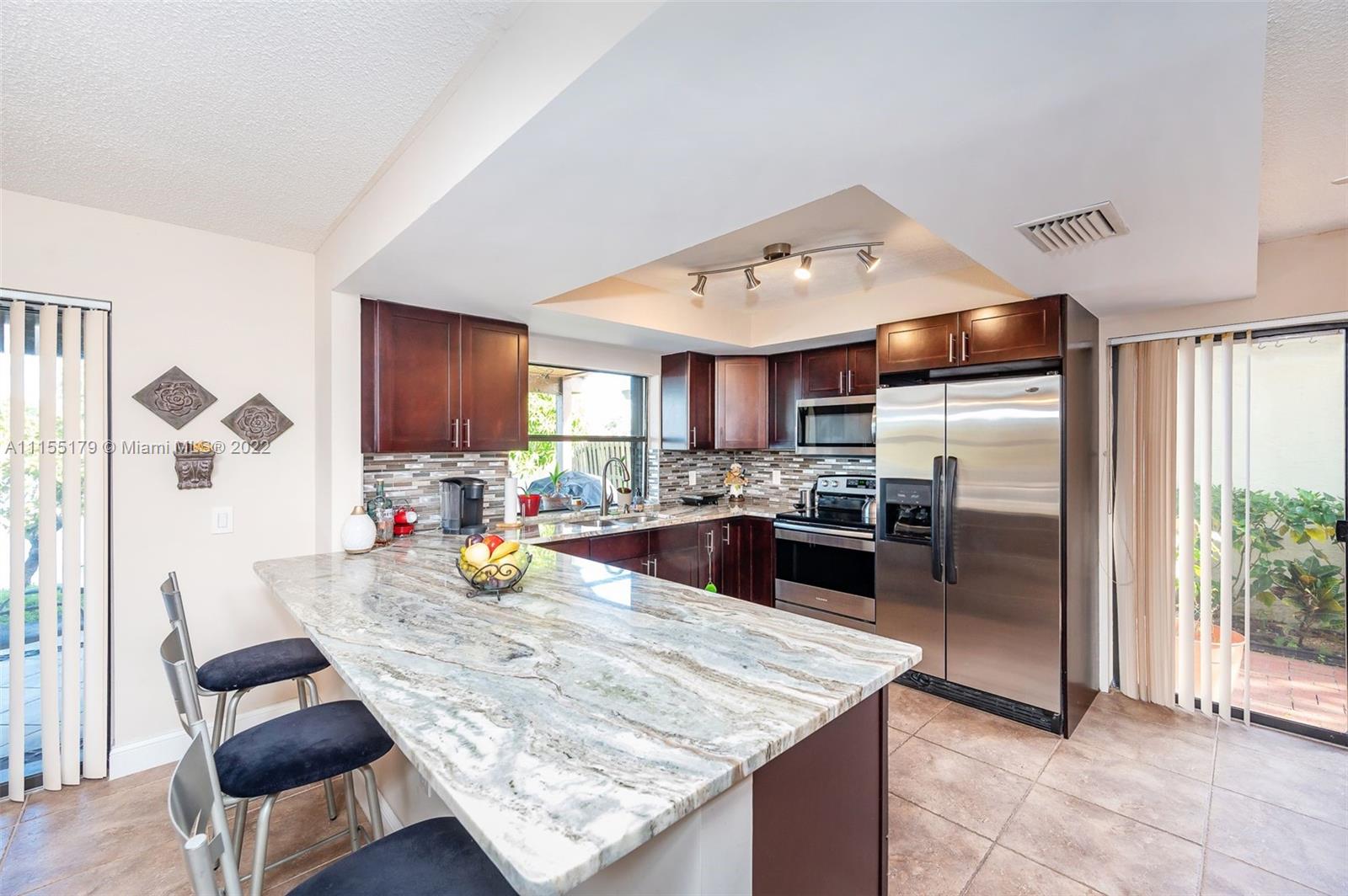 14853 Southwest 42nd Lane Miami, FL 33185 - Photo 10 of 28 a kitchen with stainless steel appliances granite countertop a stove refrigerator and a sink