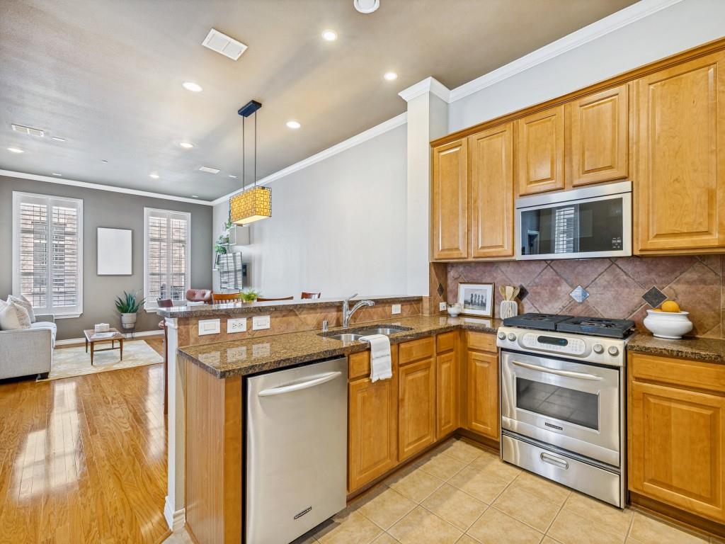15741 Seabolt Place, Unit 28 Addison, TX 75001 - Photo 37 of 37 a kitchen with stainless steel appliances granite countertop a stove top oven a sink dishwasher and white cabinets with wooden floor