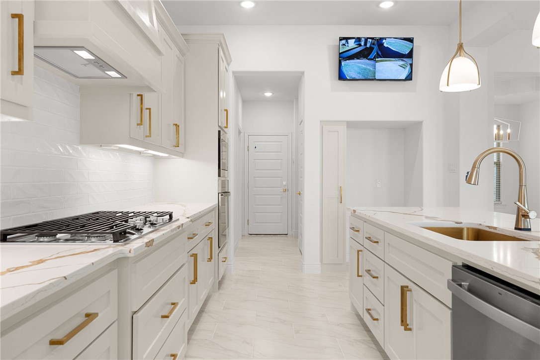6512 Agave Court Bryan, TX 77808 - Photo 21 of 42 Kitchen featuring light stone countertops, white cabinets, tasteful backsplash, appliances with stainless steel finishes, and recessed lighting