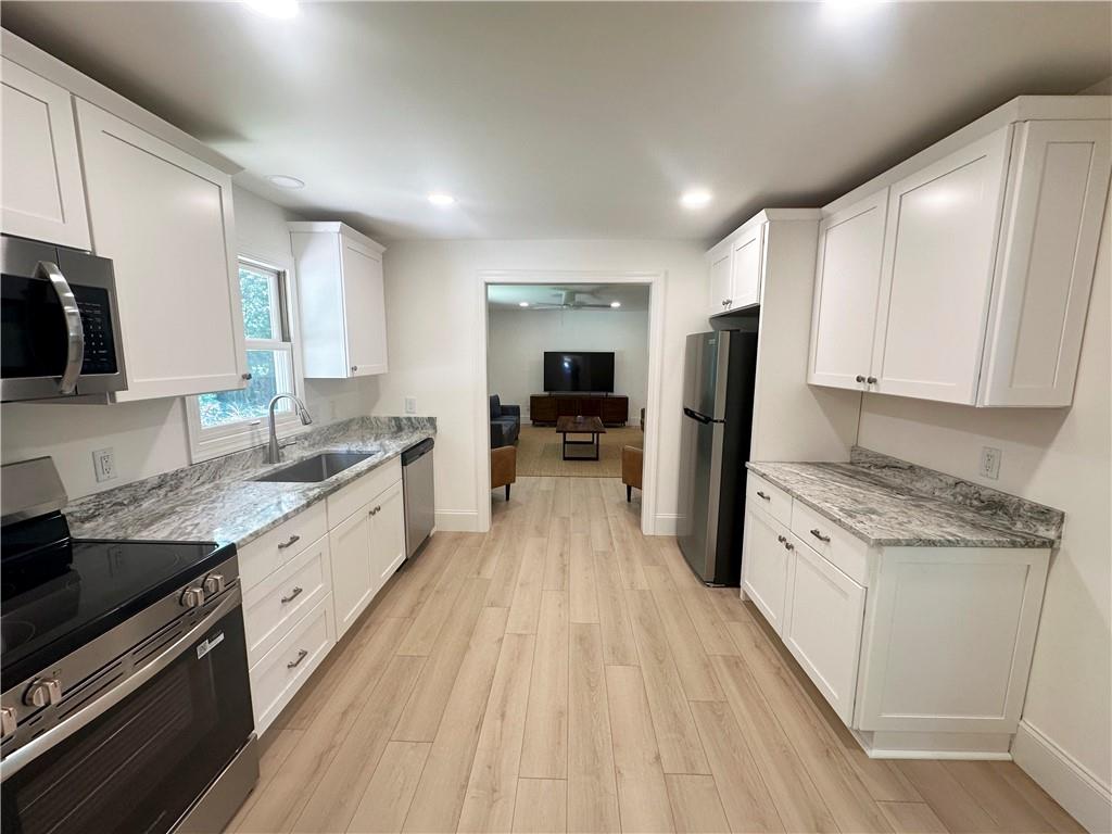 3405 Still Road Cumming, GA 30041 - Photo 6 of 28 a large kitchen with stainless steel appliances granite countertop a lot of counter space and wooden floor