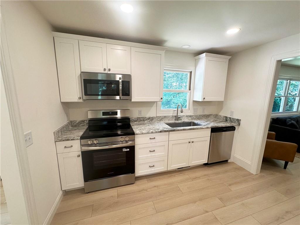 3405 Still Road Cumming, GA 30041 - Photo 7 of 28 a kitchen with a stove a sink and a microwave
