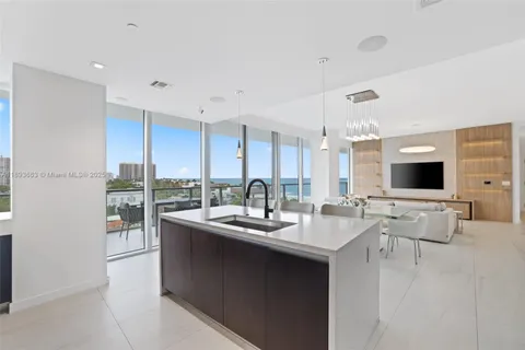 a room with stainless steel appliances kitchen island granite countertop a sink and cabinets
