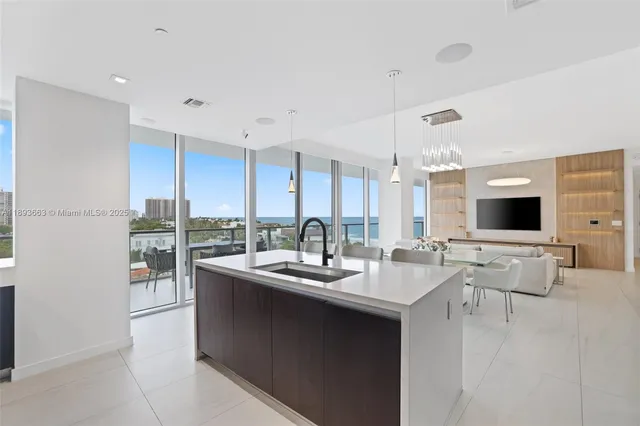 a room with stainless steel appliances kitchen island granite countertop a sink and cabinets