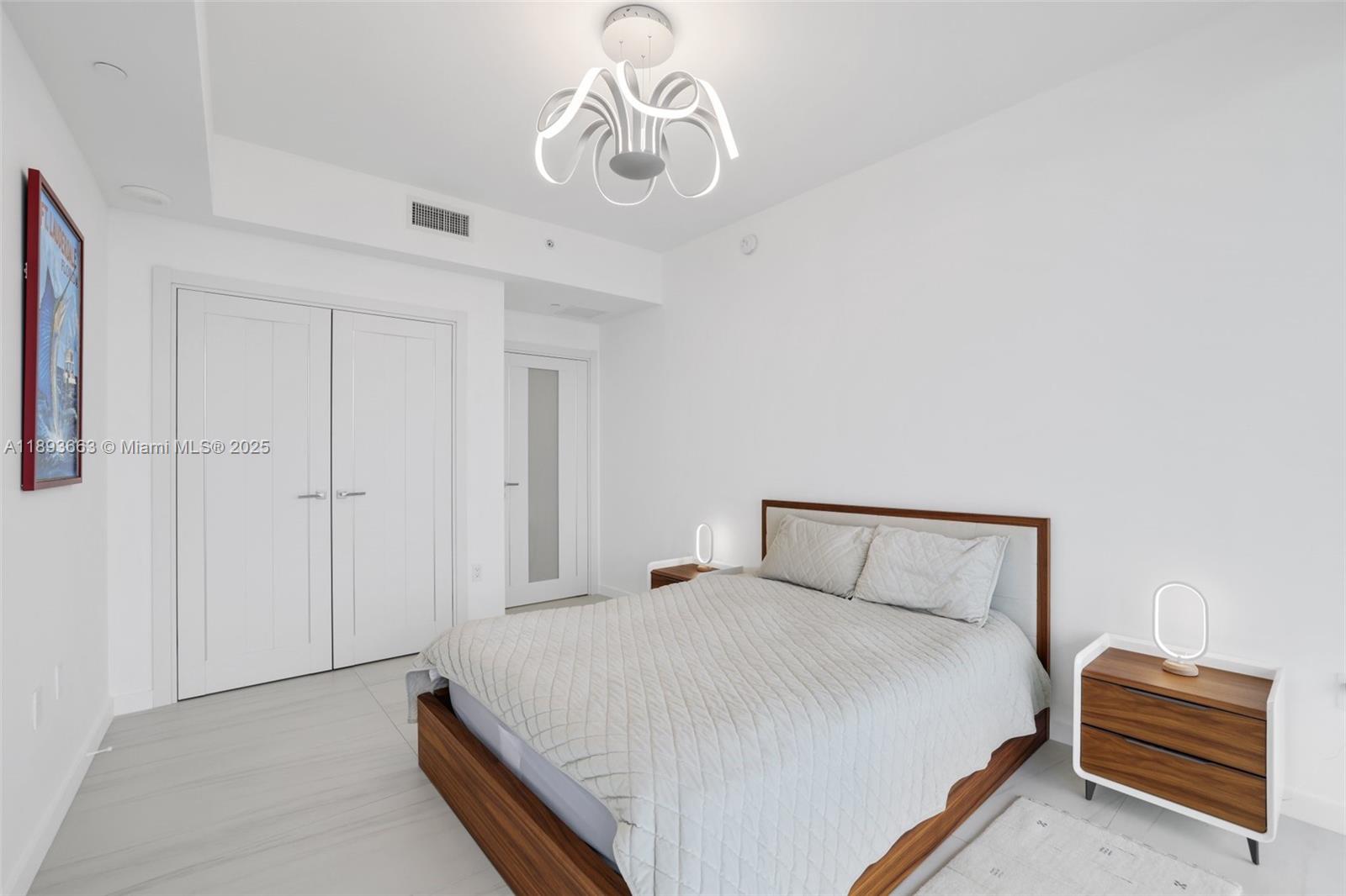 2200 North Ocean Boulevard, Unit N504 Fort Lauderdale, FL 33305 - Photo 17 of 43 a bedroom with a bed and a chandelier