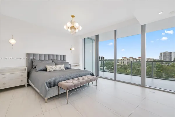 a bedroom with a large bed and a chandelier