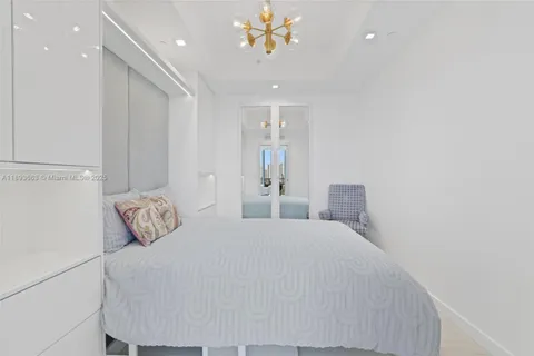 a bedroom with a bed and a chandelier