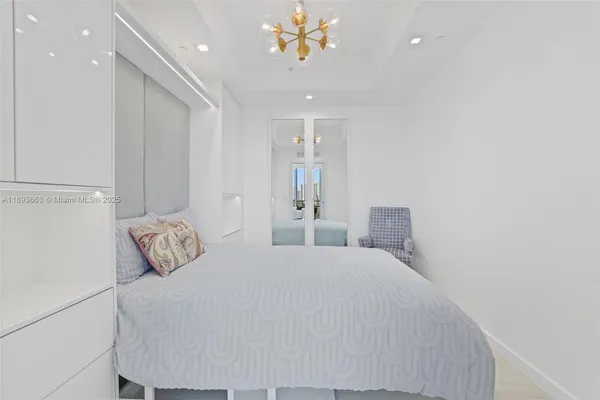 a bedroom with a bed and a chandelier