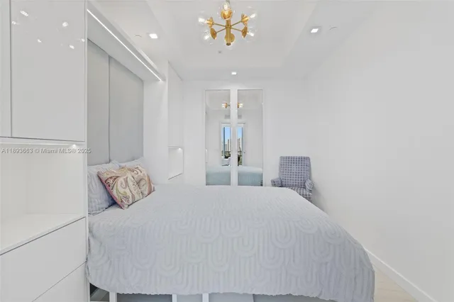 a bedroom with a bed and a chandelier